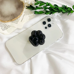 Support de téléphone patte de chat noir brillant sur smartphone blanc et décor chic