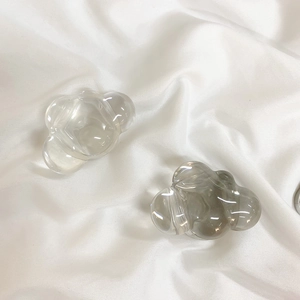 Close-up of cloud-shaped phone socket accessories on white satin fabric texture