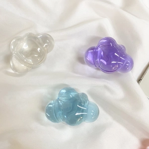 Macro detail of acrylic cloud-shaped phone socket holders in clear, purple, and blue