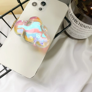 Cloud-shaped iridescent phone grip with holographic finish on a white smartphone