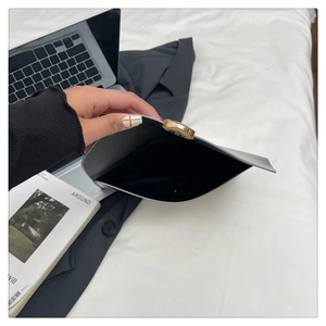 Close-up of gray leather envelope clutch with gold buckle and interior storage view