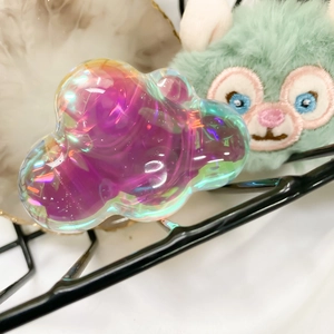 Macro shot of cloud-shaped holographic purple resin phone stand with iridescent finish