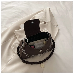 Detail view showing interior capacity and magnetic closure of brown crescent underarm bag