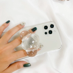 Close-up of a clear spherical Griptok phone stand mounted on a white smartphone