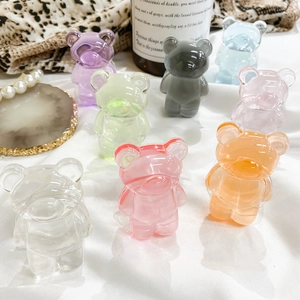 Close-up of colorful translucent resin bear phone grips on a minimalist white fabric background