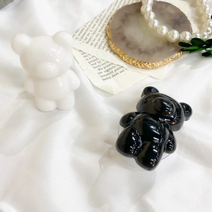 Macro detail of cute black and white bear phone socket stands on elegant satin background