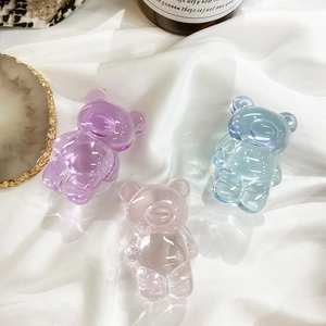 Three colorful 3D bear-shaped resin grips on white satin, focusing on jelly texture