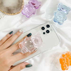 Macro shot of 3D colorful transparent resin bear phone grip on white silk background