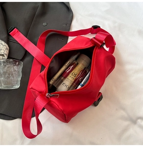 Internal storage detail of red nylon travel bag with phone and cosmetics inside