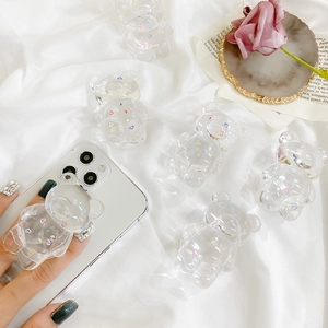 Close-up of a transparent bear phone grip with colorful hearts on a white mobile phone