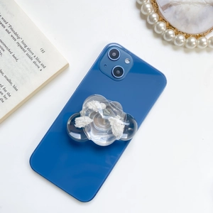 Close-up of a transparent cloud-shaped phone grip with white filling on a dark blue phone