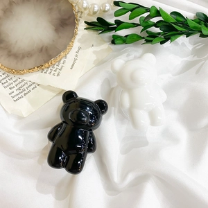 Detailed view of glossy black and white bear phone grips on a refined vanity display