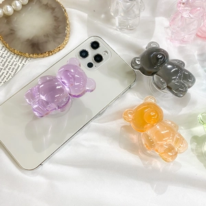 Colorful resin bear phone grip holder shown on mobile device with various color options