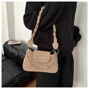Detail of khaki faux leather shoulder bag with silver flower chain and woven strap