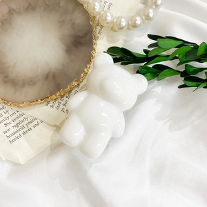 Detail of white glossy bear phone socket on elegant marble tray with pearl decor