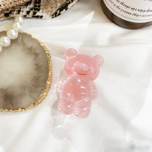 Close-up of a pink translucent jelly bear phone grip on a white fabric background