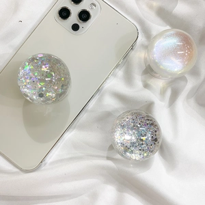 Close-up of three sparkling spherical phone grips with glitter and aurora pearl finish