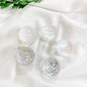 Detailed view of 5 glitter resin phone grips with silver foil on white fabric background