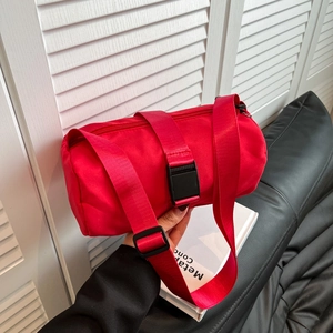 Bright red nylon cylinder shoulder bag with wide strap and adjustable buckle for travel