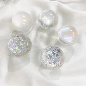 Detail showing five gradient glitter planet phone grips on white silk background