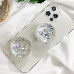 Close-up of glitter star phone grips on a white phone against a silk background