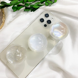 Three gradient glitter phone sockets in diamond, pearl, and laser finish on a white phone