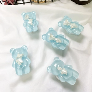 Dettaglio di supporti per telefono a forma di orso blu in resina con trama