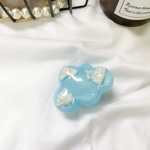 Dettaglio del supporto per telefono a nuvola blu con piccoli motivi in resina 3D