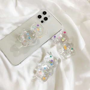 Close-up of a clear 3D bear phone grip with colorful flower sequins on a smartphone