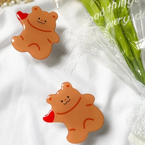 Close-up of cute caramel bear acrylic phone grip with red heart and shiny resin finish