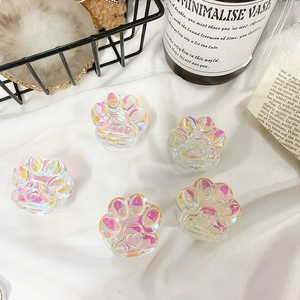 Macro shot of iridescent cat paw phone grips with heart relief on white fabric
