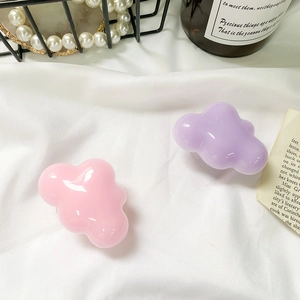 Detailed view of pink and purple cloud-shaped phone grips with a glossy resin finish