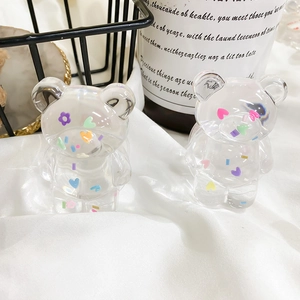 Close-up of two transparent bear phone grips with colorful heart and flower patterns