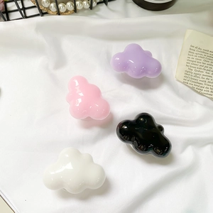 Close-up of four solid color cloud-shaped phone sockets on soft white satin fabric