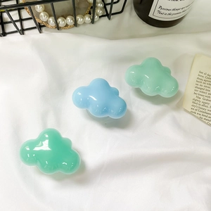 Detail view of cloud-shaped phone socket grips in mint green and light blue resin