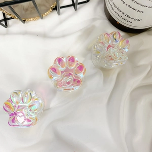 Detail view of aurora cat paw phone grips with 3D heart relief on white fabric