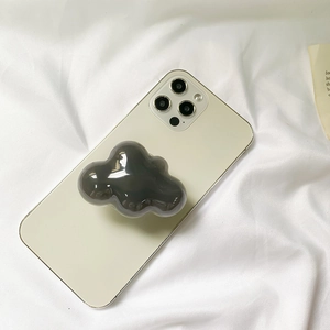 Detail shot of a dark grey cloud-shaped glossy resin folding phone grip on a smartphone