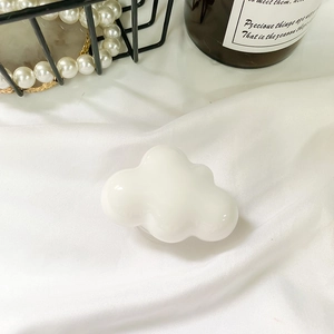 Minimalist white resin cloud-shaped phone socket grip on cozy aesthetic background