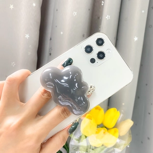 Close-up of translucent dark grey cloud phone grip on a white smartphone