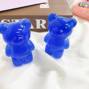 Close-up of two deep blue transparent bear-shaped resin grips for phone stands