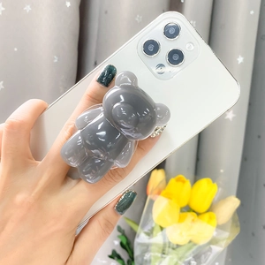 Minimalist grey bear collapsible phone socket stand attached to a white smartphone