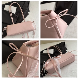 Close-up of pink rectangular shoulder bag with lace trim and ribbon bow detail