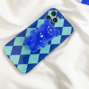 Blue checkerboard phone case with a 3D transparent bear stand on white fabric