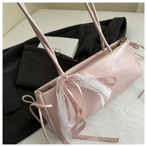 Detailed view of the pink faux leather shoulder bag with white lace bow and side drawstrings
