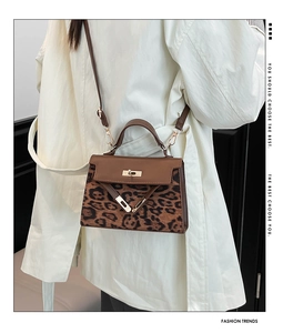 Leopard print patchwork shoulder bag with gold hardware shown on a model