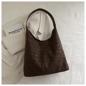 Macro view of leopard print faux suede tote bag on white textured background with book