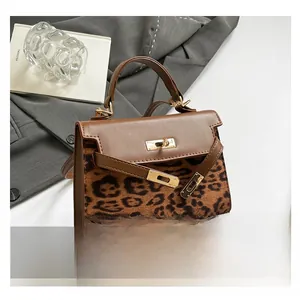 Detail of leopard print faux fur and brown leather paneling on a structured handbag