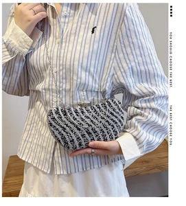 Detailed view of striped crystal rhinestones on an elegant square evening clutch bag