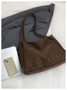 Flat lay of leopard print tote bag with laptop and blazer for work commute style