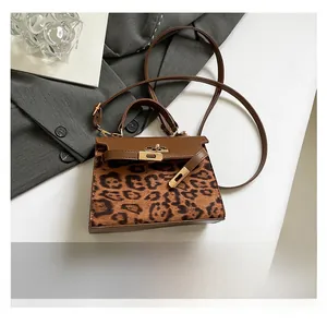 Leopard print handbag detail showing gold hardware lock and smartphone size reference